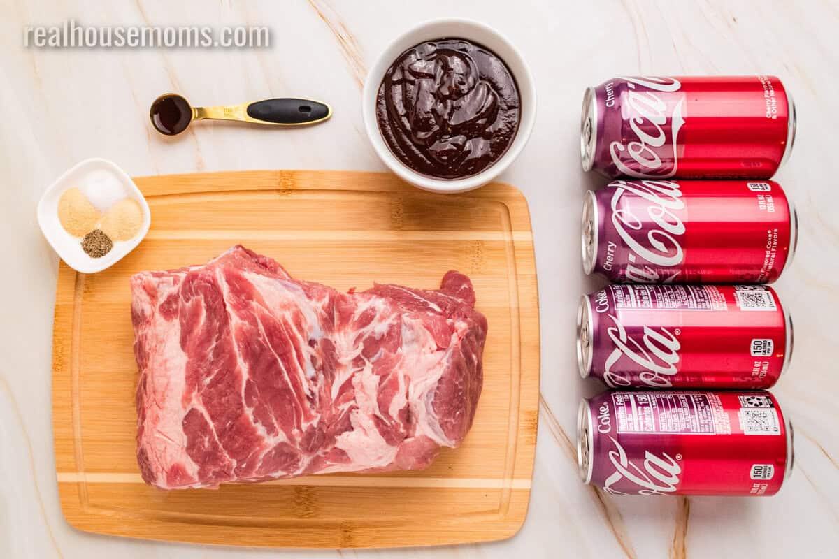 ingredients to make cherry cola pulled pork laid out on a marble counter