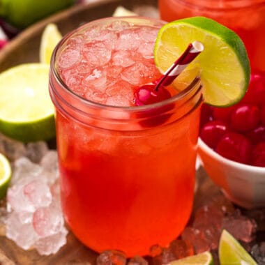 square image of cherry limeade in a mason jar with a cherry and lime slice for garnish