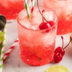 square image of 3 glasses of cherry poke cake cocktails with cherries and lime slices