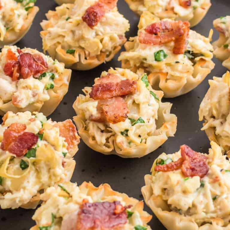 square image of chicken artichoke bites on a serving platter