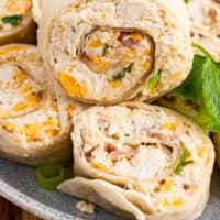 Chicken Bacon Ranch Pinwheels piled up on a plate with recipe name at the bottom