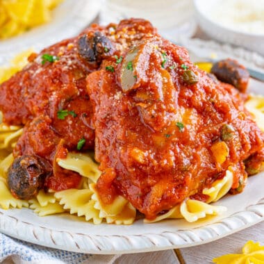 square image of chicken cacciatore plated on a bed of bowtie pasta