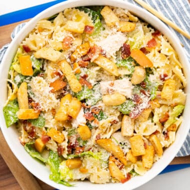 square image of chicken casesar pasta salad in a serving bowl