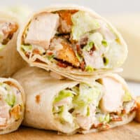 square image of a chicken caesar wrap cut in half to show the filling