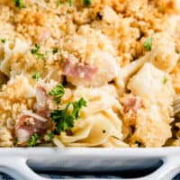 close up of chicken cordon bleu casserole in a baking dish with recipe name at bottom