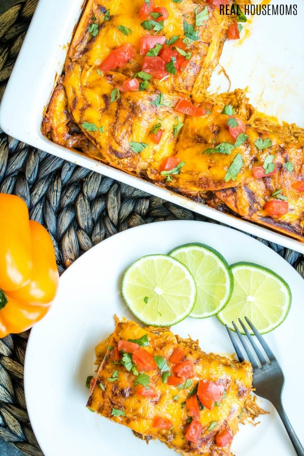 chicken enchilada casserole on a plate with limes
