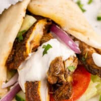 Image of two chicken shawarma wraps on a plate with the. title of the post on top in pink and black lettering