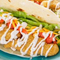 Easy Chicken Soft Tacos are a kid-approved taco night win! Crispy chicken and taco fixings are drizzled with homemade crema sauce for a quick 15-minute meal!