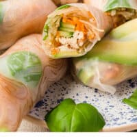 chicken spring rolls on a plate with one cut in half to show filling with recipe name at the bottom
