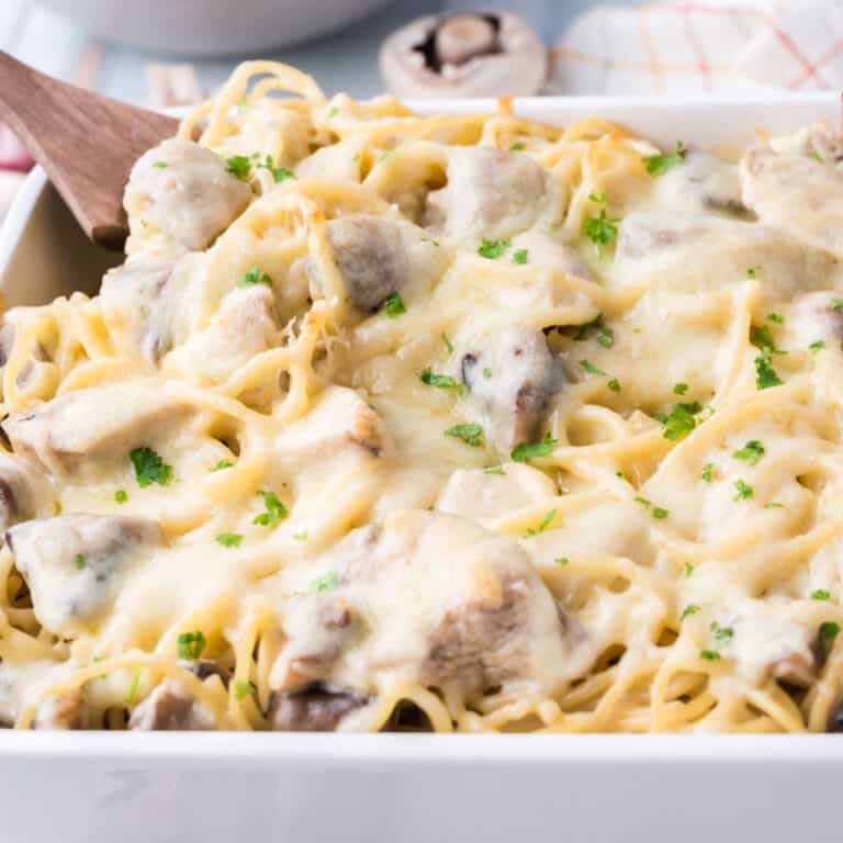 square image of chicken tertazzini in a baking dish with chopped parsley