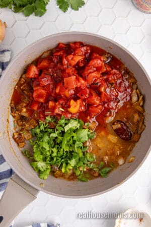 fire-roasted tomatoes, cilantro, and lime juice added to a skillet of seasoned sautéed onion