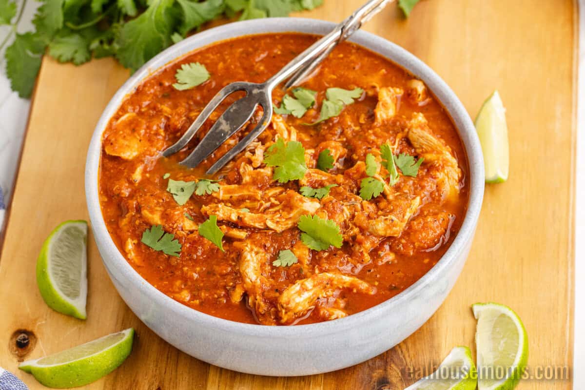 slow cooker chicken tinga in a serving bowl with tongs