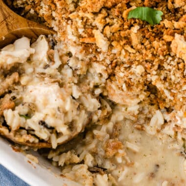 square image of chicken & wild rice casserole with a portion taken out to show creamy filling