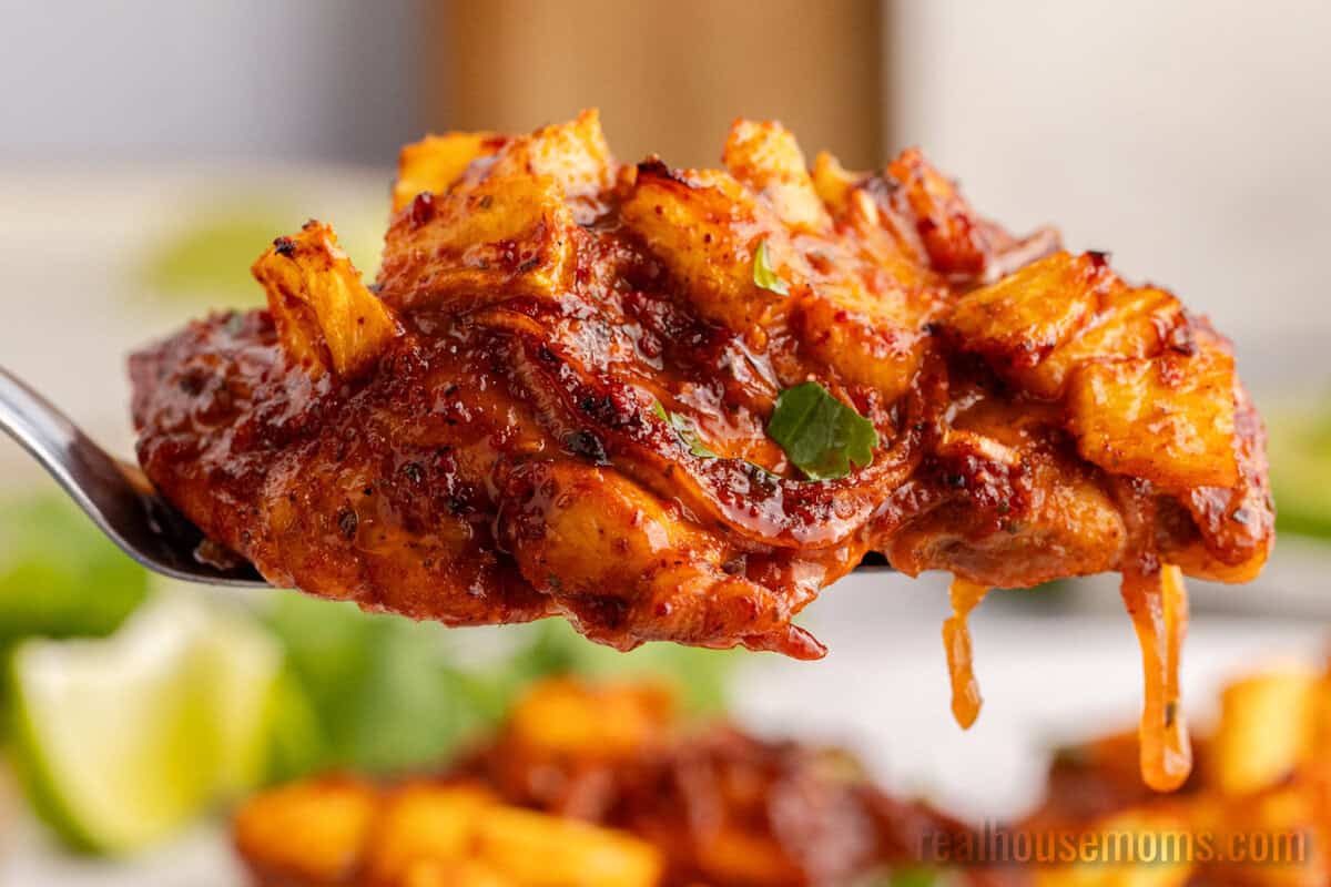piece of chicken al pastor on a spatula over the baking sheet