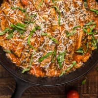 chicken with pomodoro sauce in a cast iron skillet with recipe name at the bottom