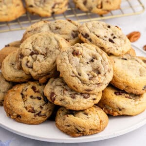 square image of chocolate chip butter pecan cookies piled on a plate