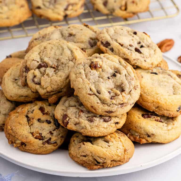square image of chocolate chip butter pecan cookies piled on a plate