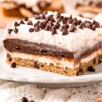 slice of chocolate chip cookie lasagna on a plate with recipe name at the bottom