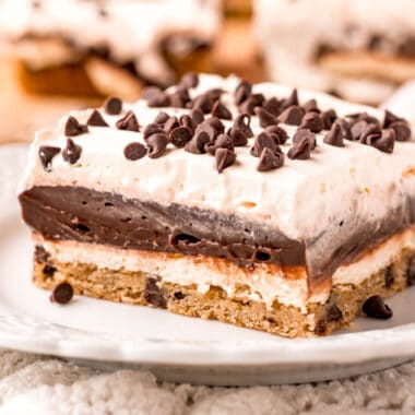 square image of a slice of chocolate chip cookie lasagna on a plate