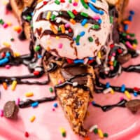 slice of chocolate chip skillet cookie topped with ice cream, chocolate sauce, and sprinkles with recipe name at the bottom