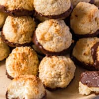 pile of chocolate dipped coconut macaroons on a plate with recipe name at the bottom