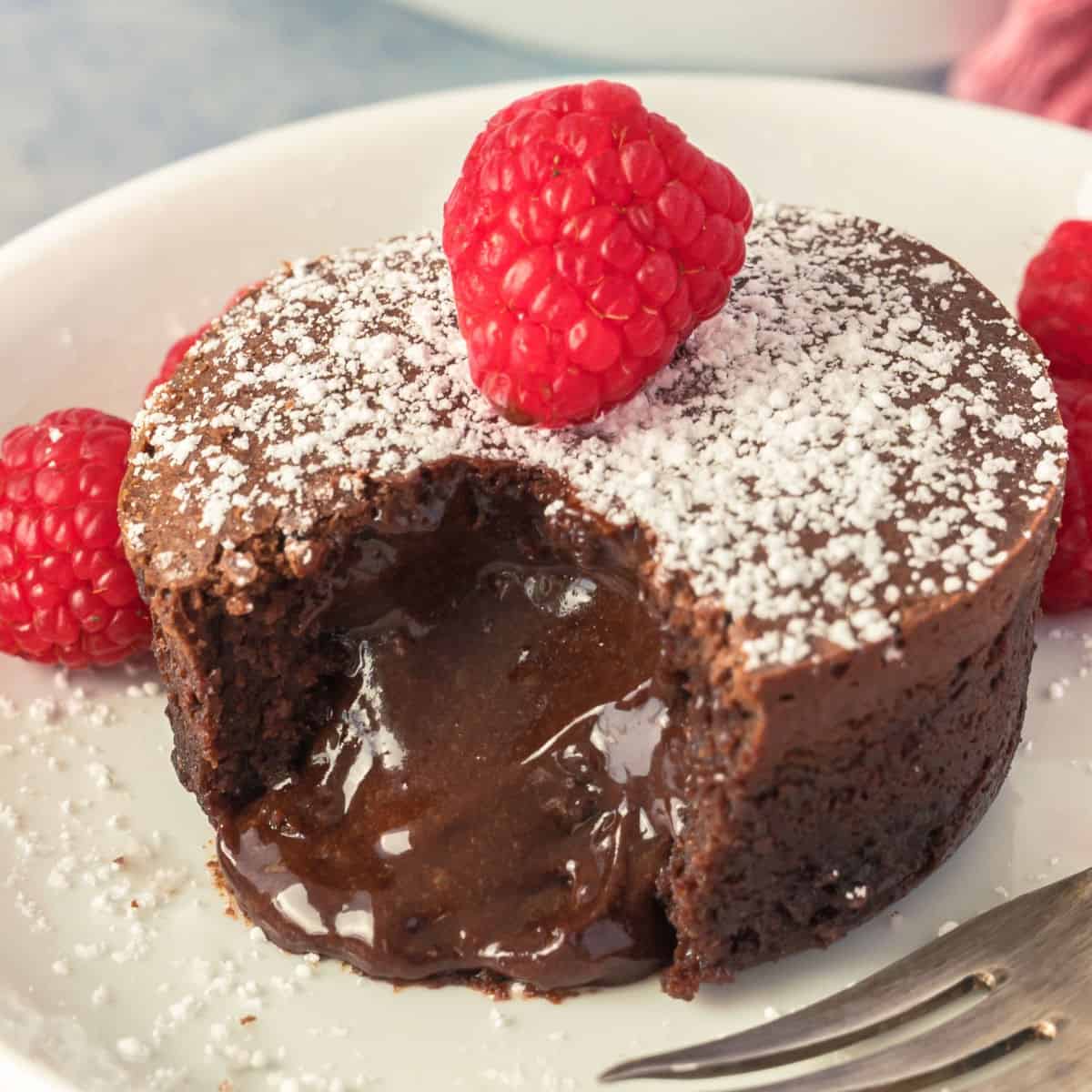 square image of chocolate lava cake cut open to let the molten center ooze out of the cake