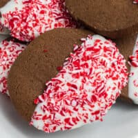 square image of chocolate peppermint cookie dipped in white chocolate and candy cane bits