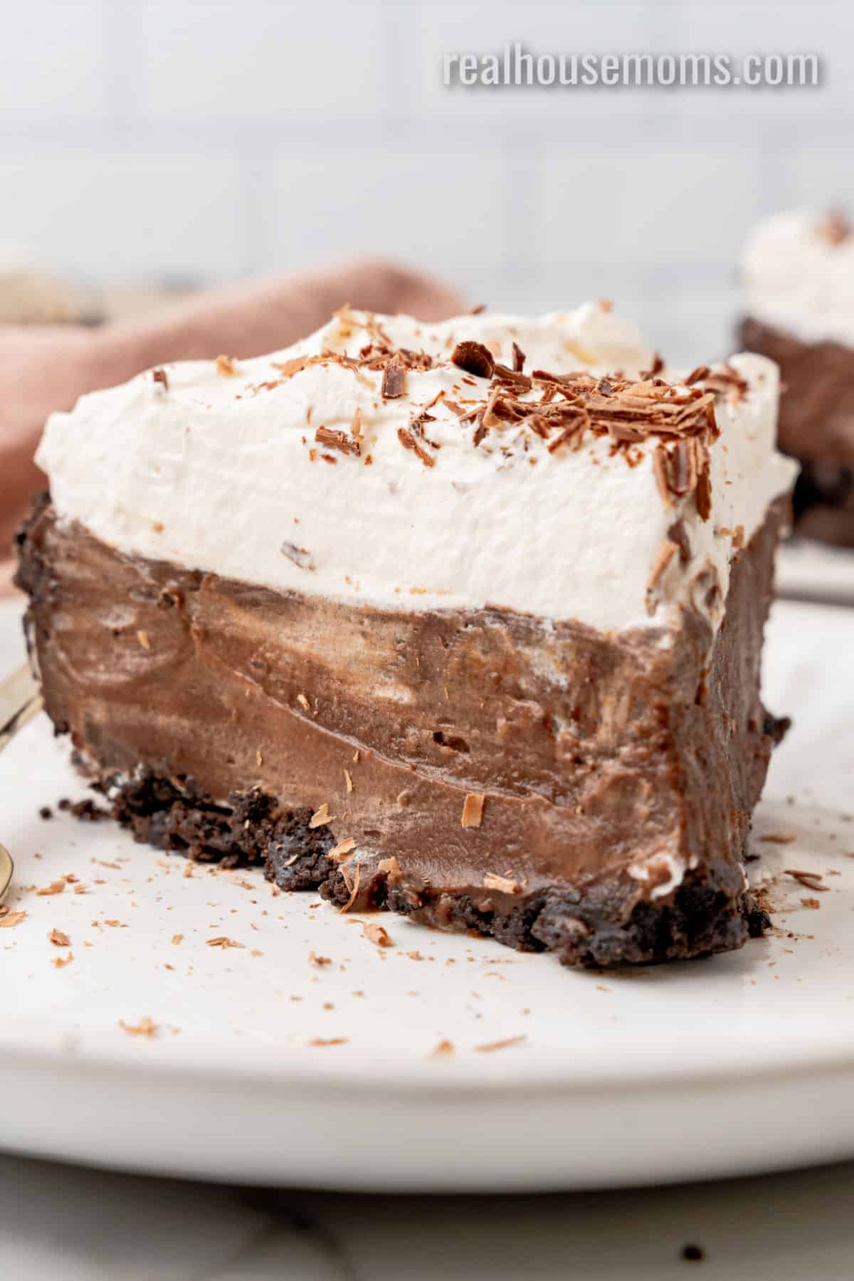 side view of a slice of chocolate pudding pie on a small white plate