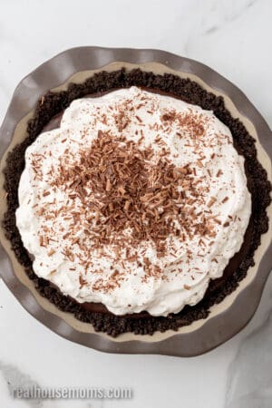 chilled chocolate pudding pie topped with whipped cream and topped with chocolate savings