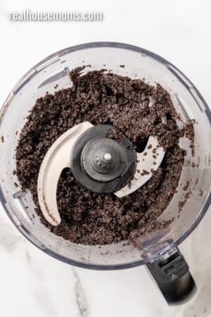 melted butter and Oreo crumbs mixed together in a food processor bowl