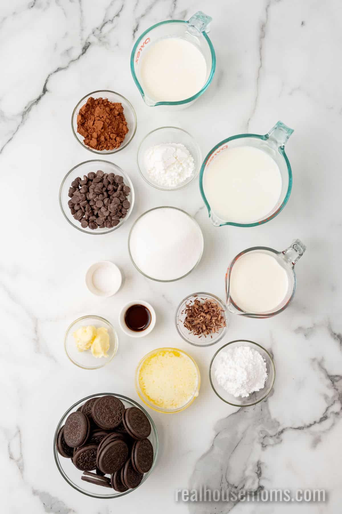 ingredients to make chocolate pudding pie with Oreo crust and whipped cream in bowls on a counter