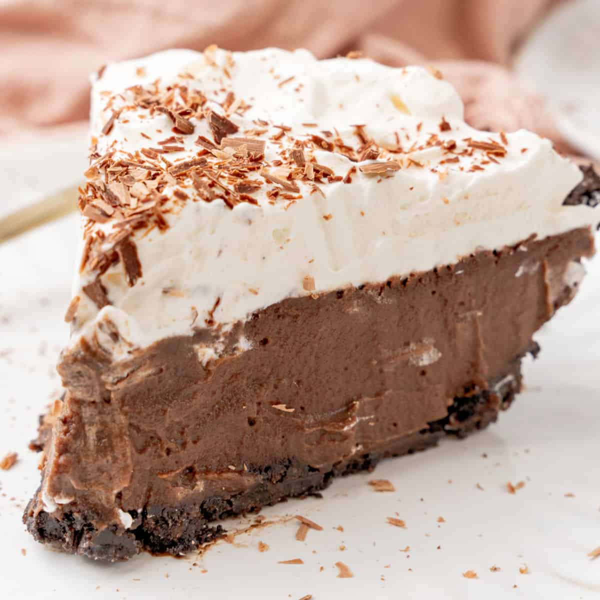 square image of a slice of chilled chocolate pudding pie on a small white plate