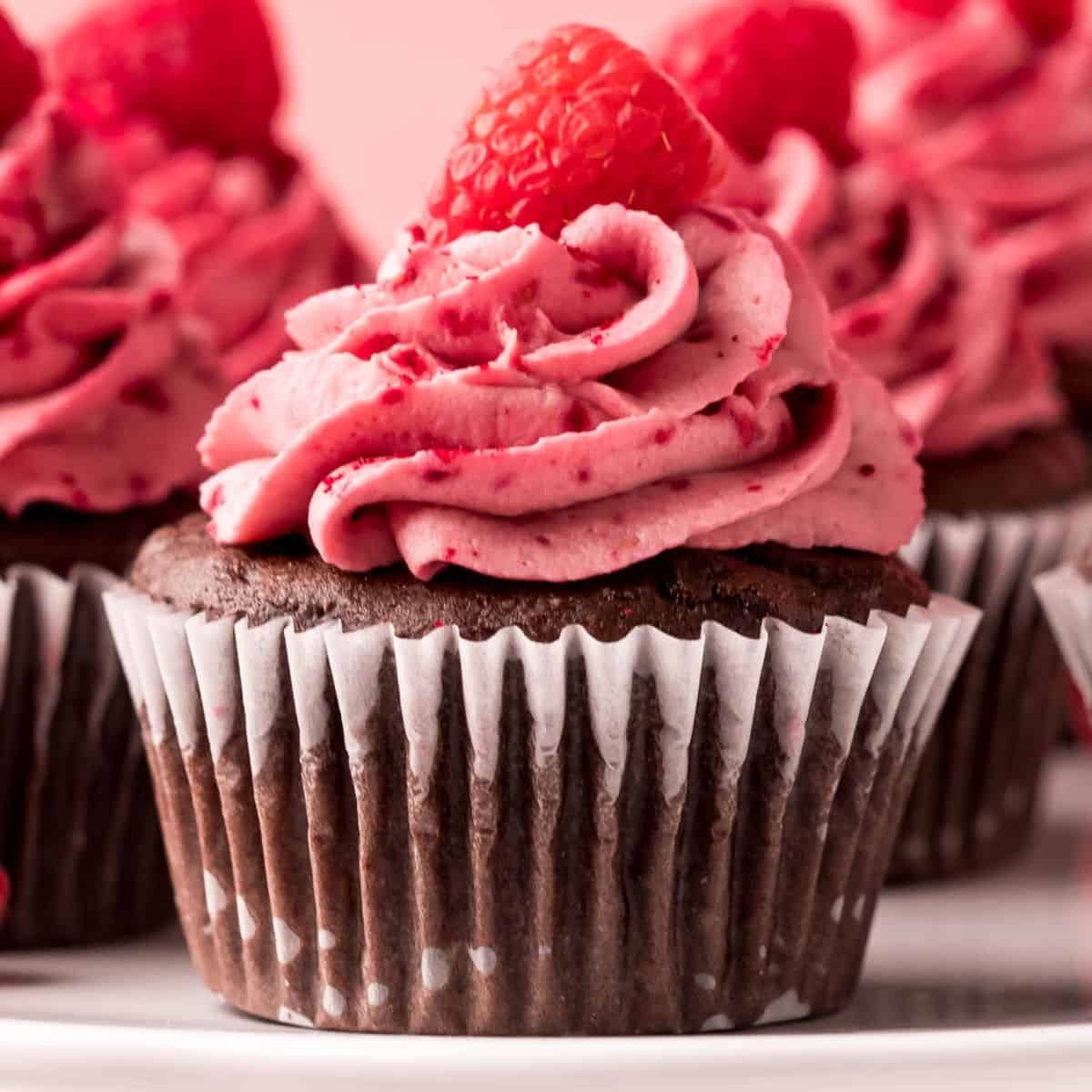 square image of chocolate raspberry cupcakes on a cake stand