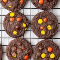 chocolate reese's piece cake mix cookies on a wire rack after cooling with the titlem of the post on top of the image in brown and black lettering