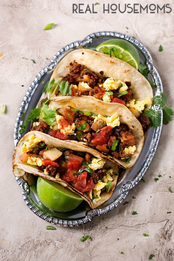 Chorizo and Potato Breakfast Tacos lined up on a plate with limes