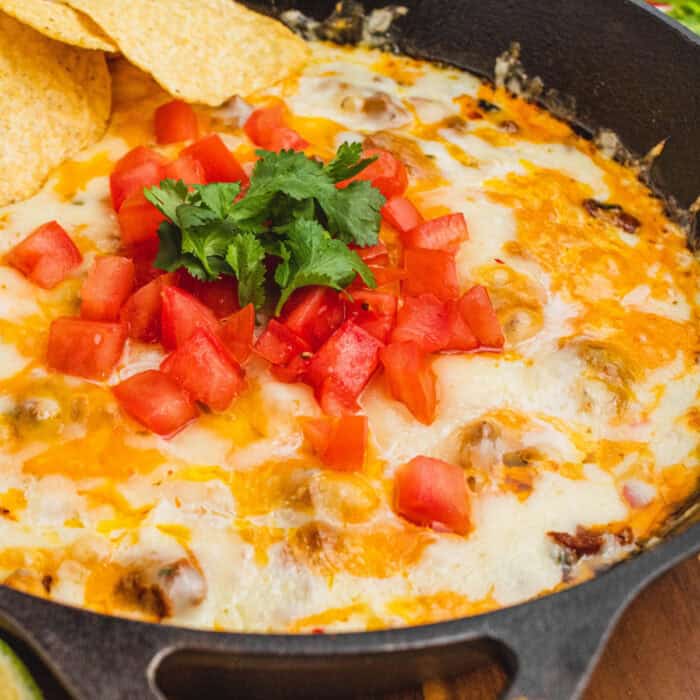 square image of chorizo queso fundido with tortilla chips in a skillet
