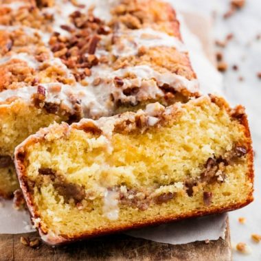 cinnamon coffee cake loaf on a board with a slice