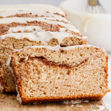 square image of cinnamon pecan coffee cake loaf slices drizzled with vanilla glaze