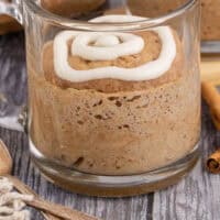 cinnamon roll mug cake topped with cream cheese icing with recipe name at the bottom