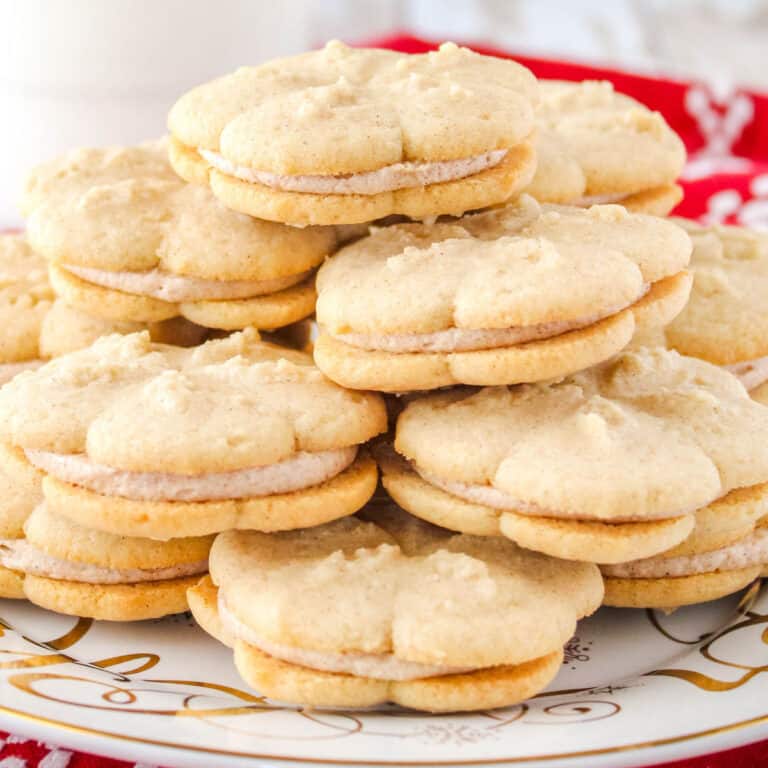 square image of cinnamon spritz sandwich cookie stacked on a plate