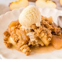 classic apple crisp on a plate with ice cream with recipe name at the bottom