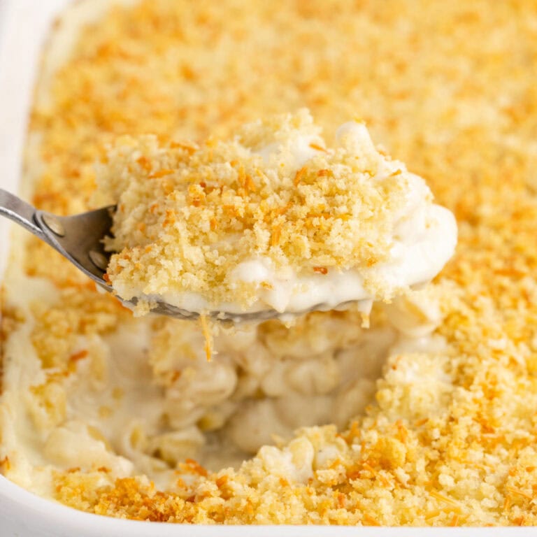 square image of a spoonful of classic baked macaroni and cheese over the baking dish
