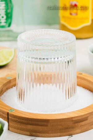 rocks glass turned upside down in a dish of margarita salt