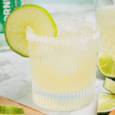 square image of a classic margarita in a rocks glass with a salt rim and lime slice