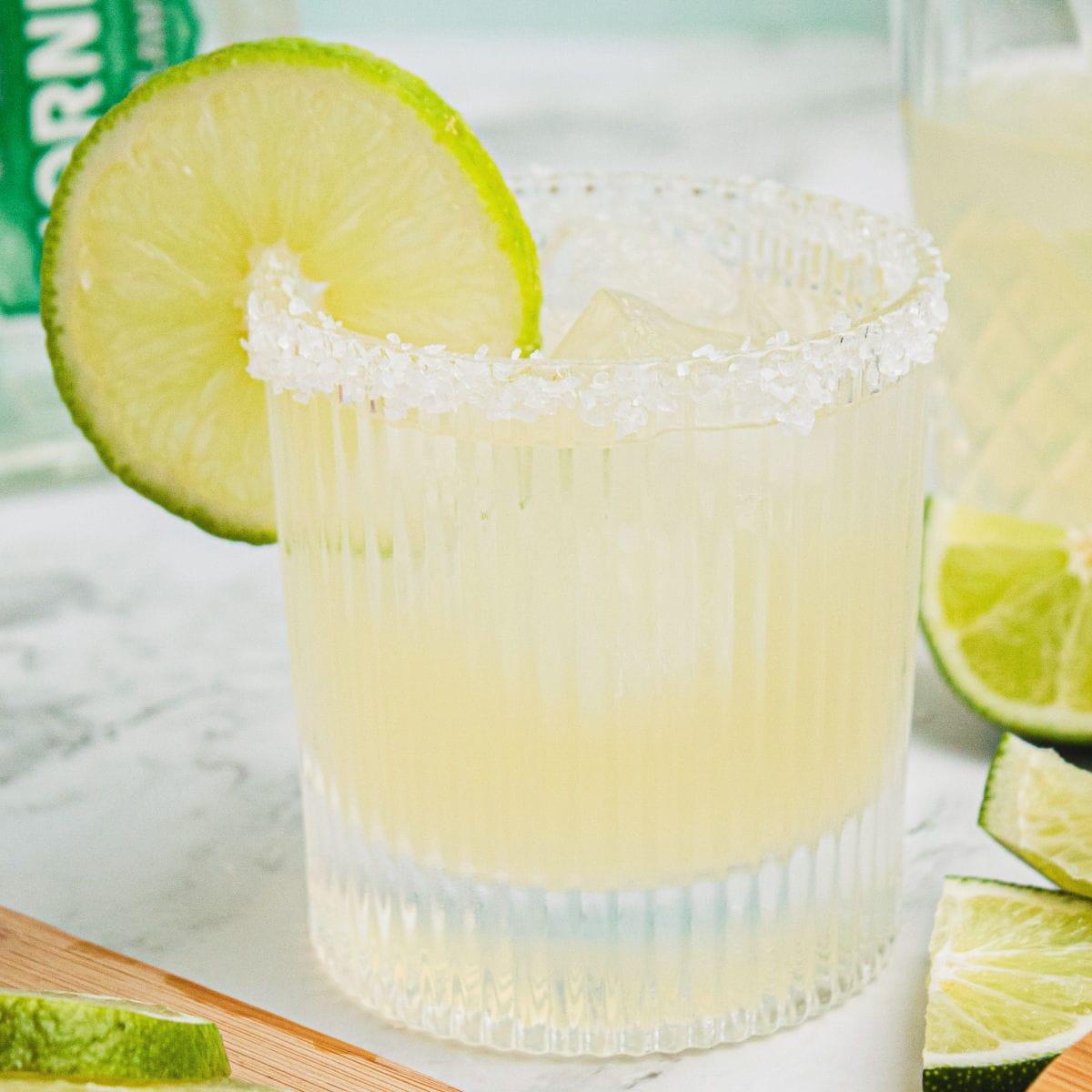 square image of a classic margarita in a rocks glass with a salt rim and lime slice
