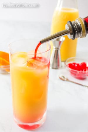 grenadine being pour into a cocktail