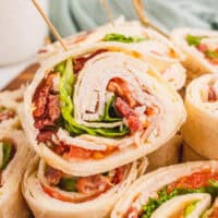 square close up image of a club sandwich pinwheels on a platter