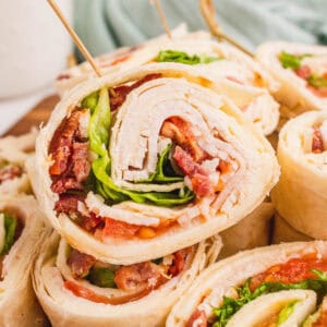 square close up image of a club sandwich pinwheels on a platter