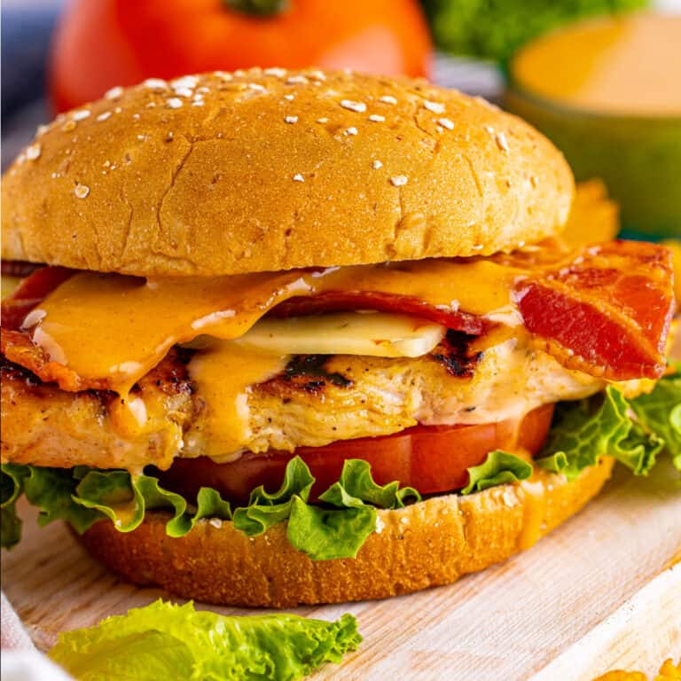 square image of a copycat chick fil a grilled chicken club on a wooden board