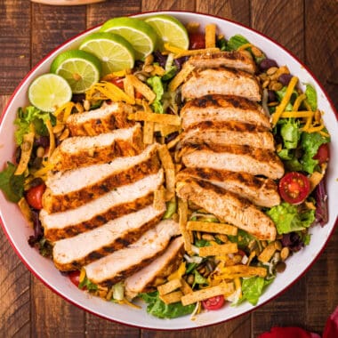 square image of copycat chick fil a spicy southwest salad with sliced limes for garnish